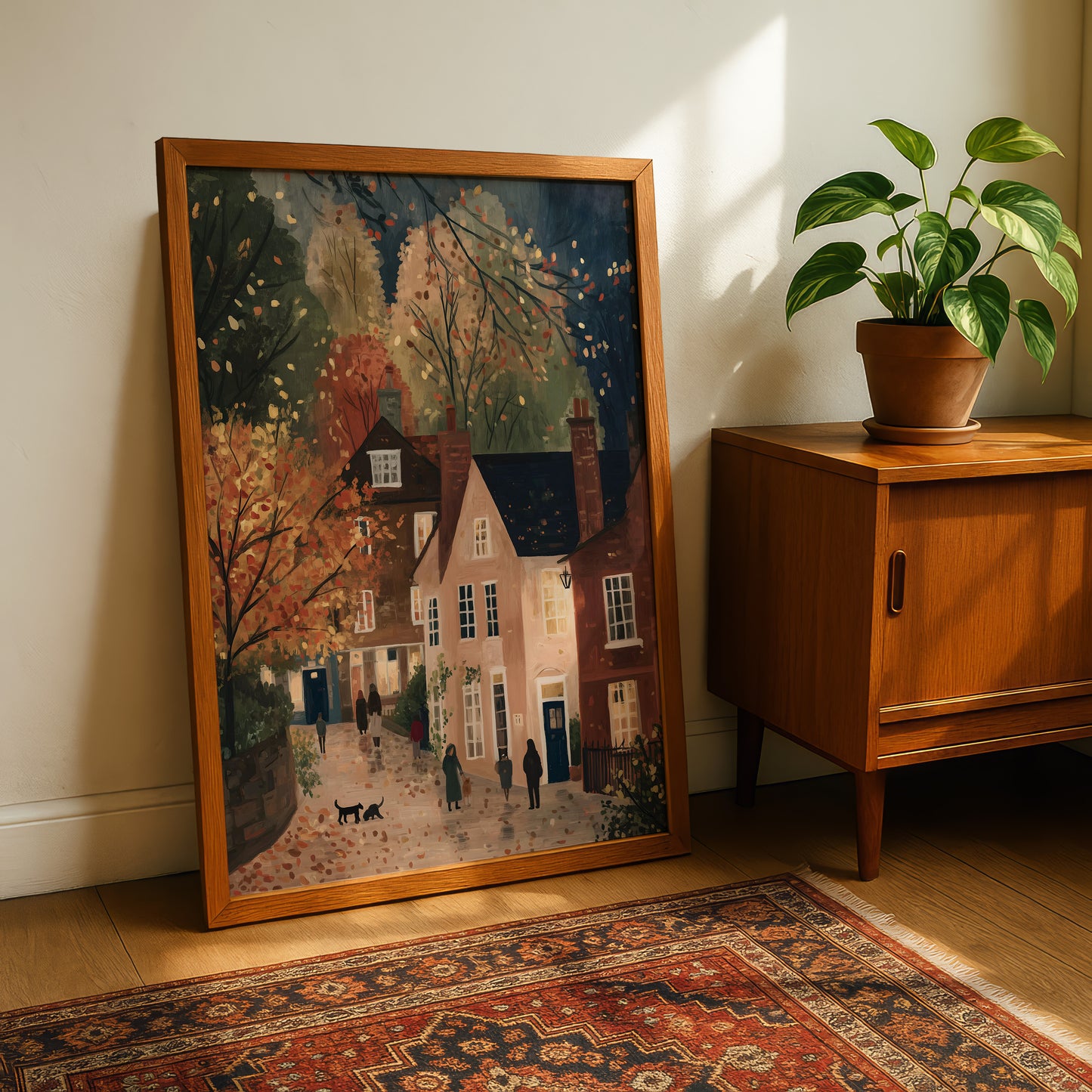 a framed painting of a quaint village scene, with a wooden cabinet and a potted plant in the background.