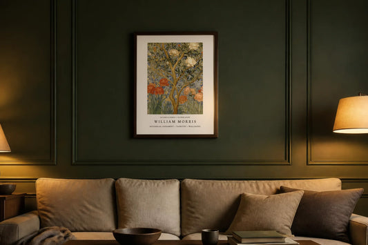 William Morris Autumn Peony Tree Print in a dark wood frame above a sofa on forest-green panelled wall