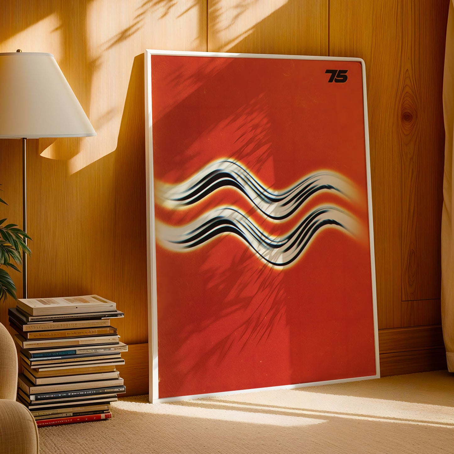 a large, vibrant red poster with a wavy design on it, placed on a wooden wall. Next to the poster, there is a stack of books and a lamp.