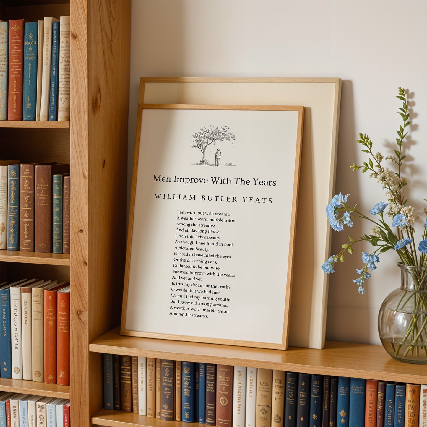 A framed poster of William Butler Yeats' poem "Men Improve With The Years" is displayed on a bookshelf, accompanied by a vase of blue flowers.