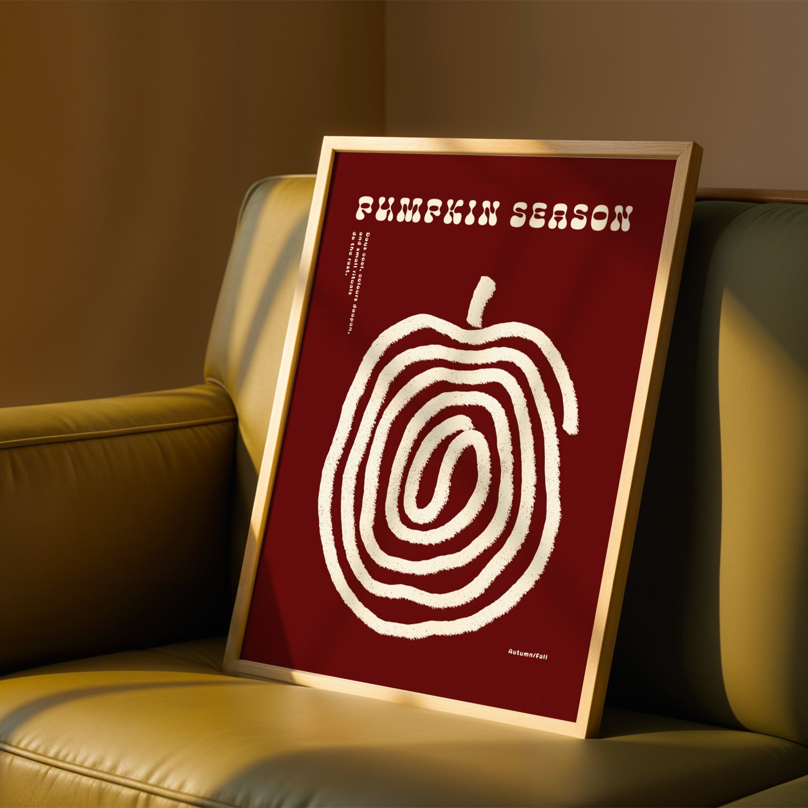 a framed poster with a red background and a white spiral design, placed on a beige couch.