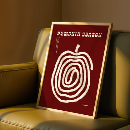a framed poster with a red background and a white spiral design, placed on a beige couch.