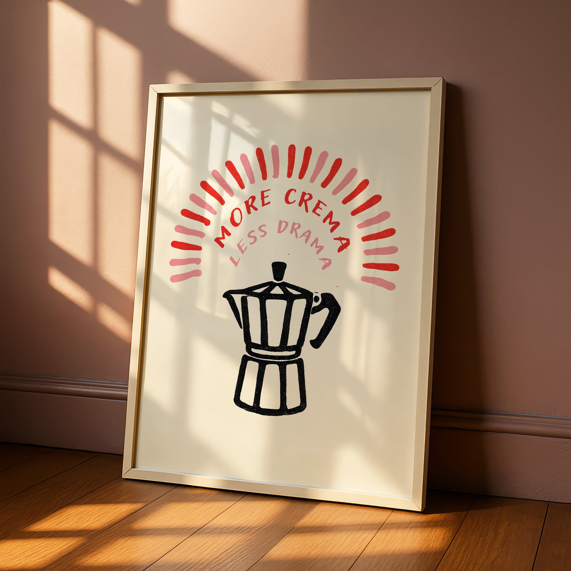 a framed poster with a black and white illustration of a coffee maker and the text "MORE CREMA LESS DRAMA" in red and pink colors.