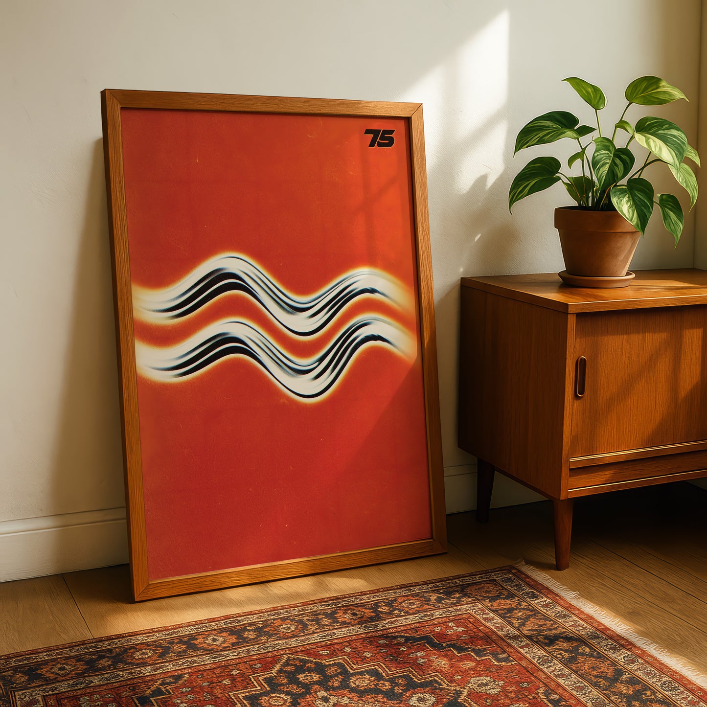 a large framed poster with a vibrant red background and abstract black and white wave-like patterns, leaning against a wall next to a wooden cabinet and a potted plant.