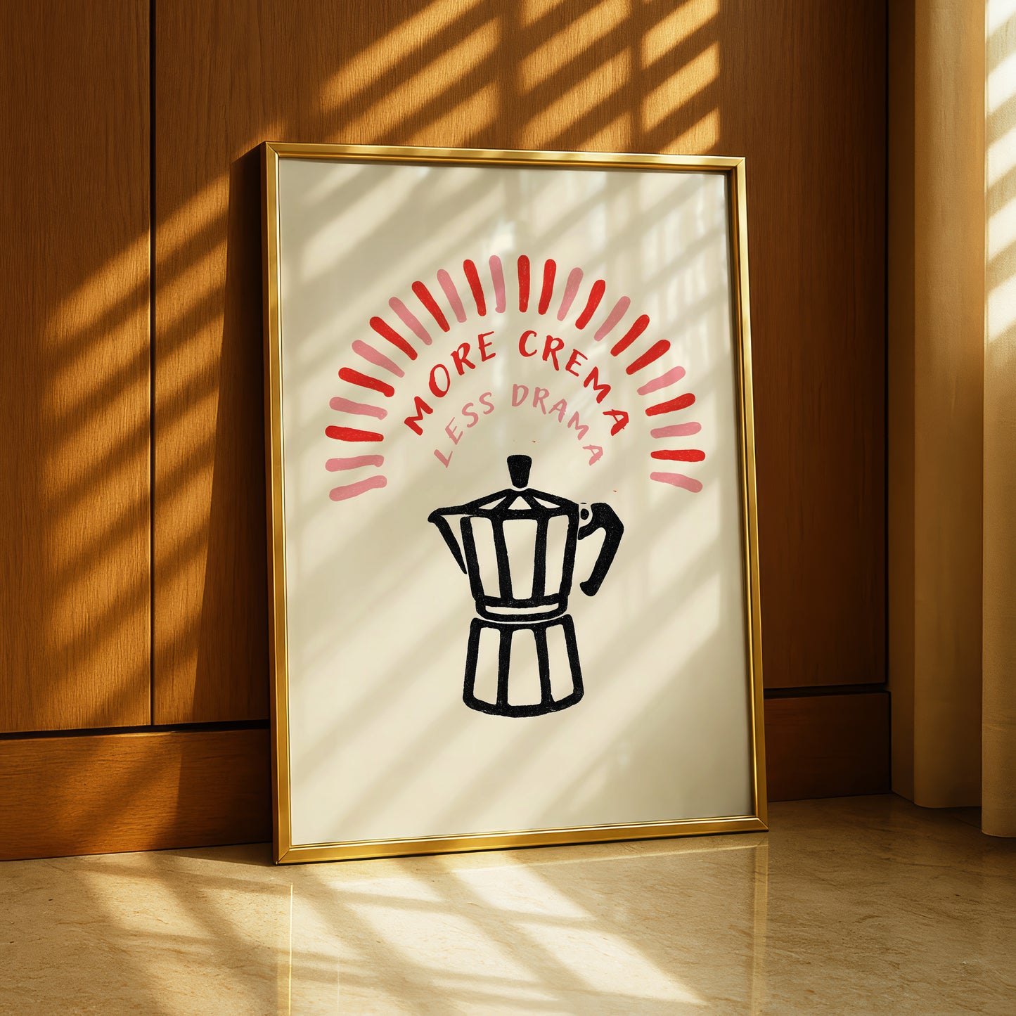 A framed poster with the text "MORE CREMA LESS DRAMA" and a black silhouette of a coffee maker.