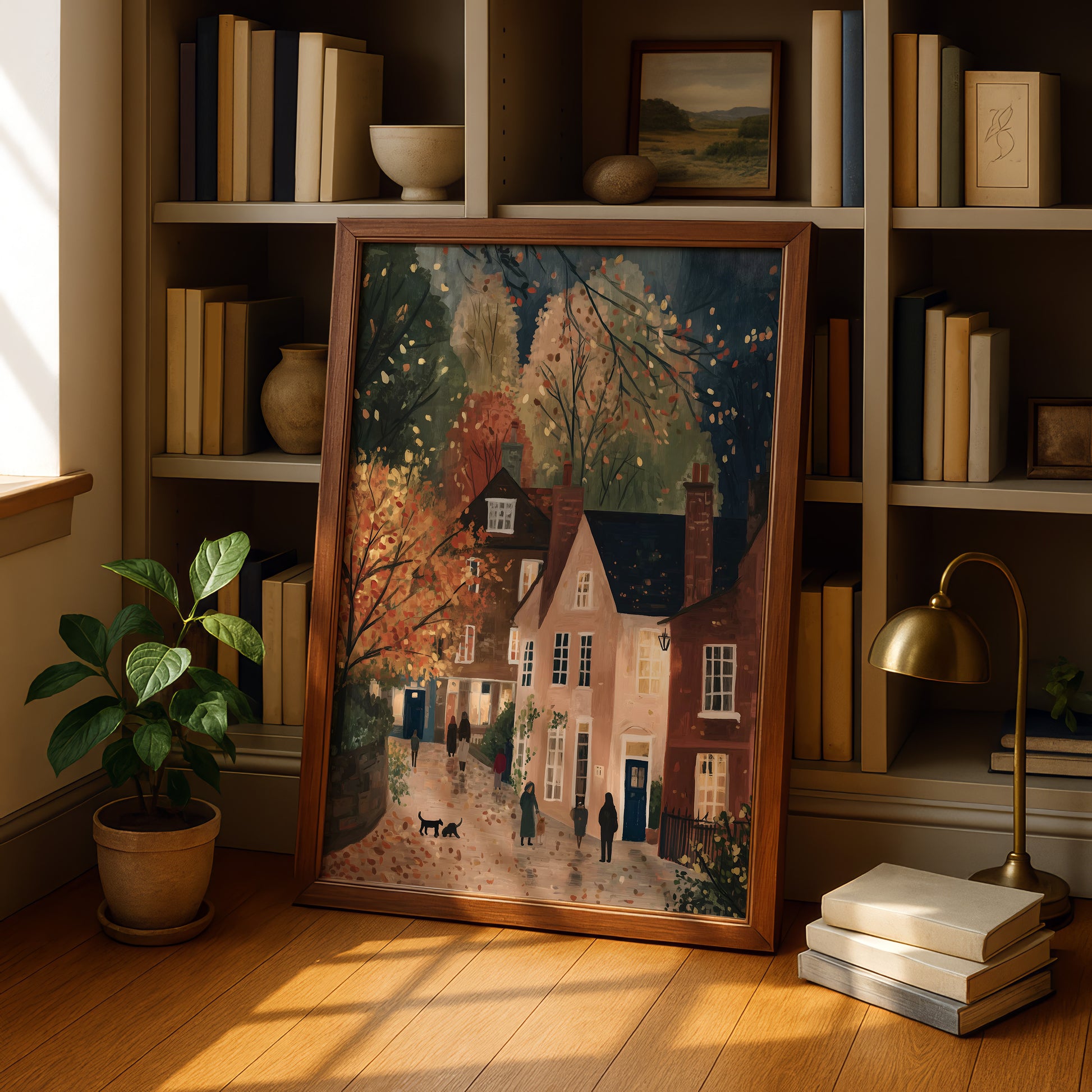 a framed painting of a quaint village scene, with a house, trees, and people walking along a path. The painting is displayed on a wooden shelf, surrounded by books and a lamp, creating a cozy and intellectual atmosphere.