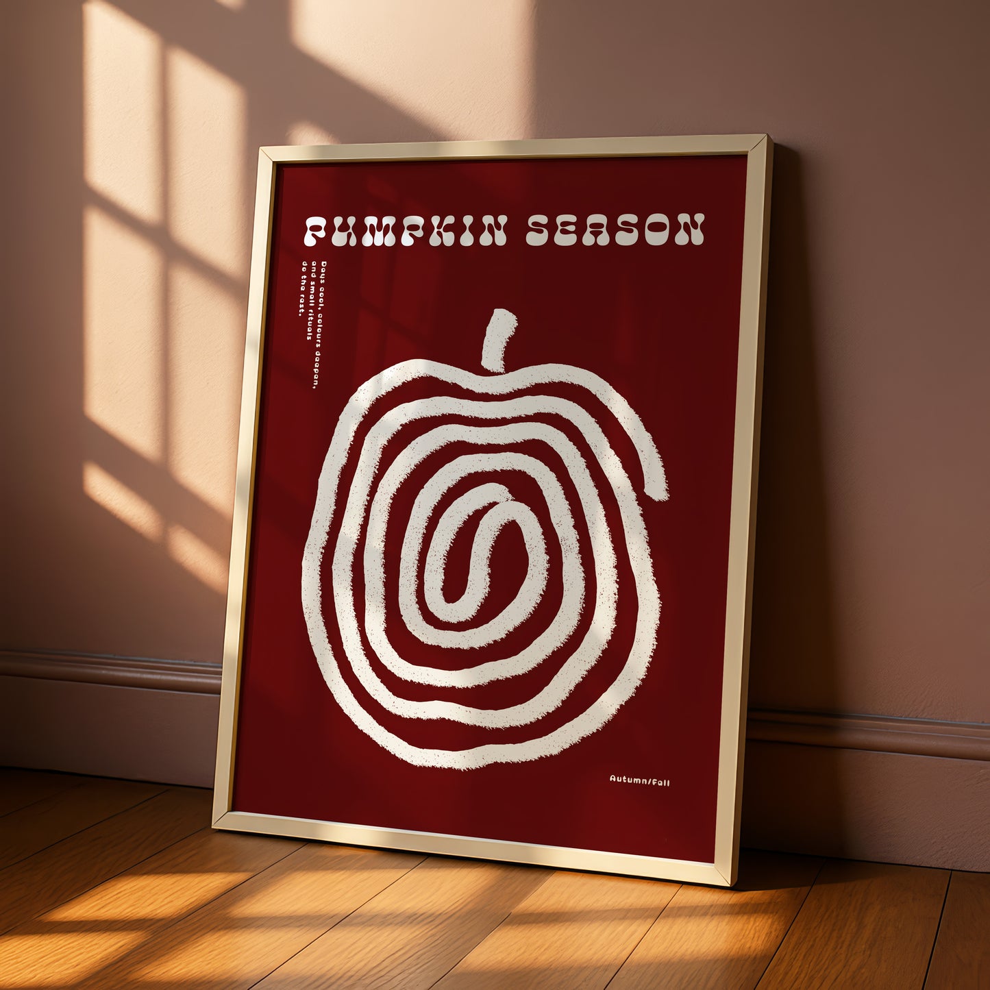 A framed poster with a red background and a white spiral design, sitting on a wooden floor.