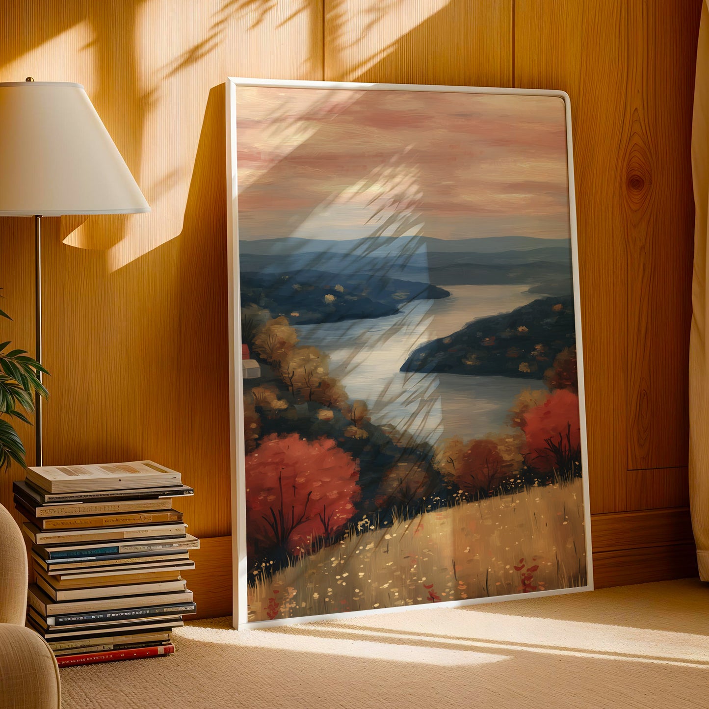 a large framed painting depicting a serene landscape with a river, mountains, and trees in autumn colors.
