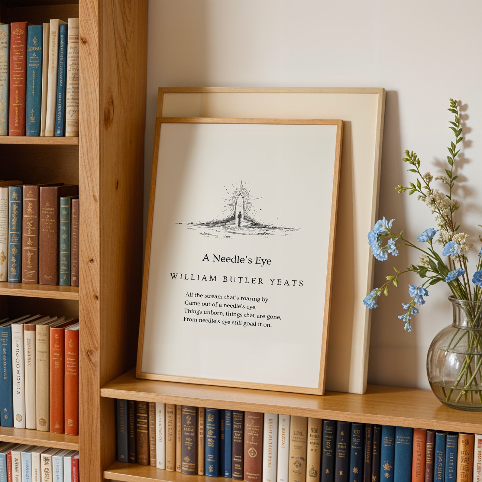 A framed quote by William Butler Yeats, "A Needle's Eye", is displayed on a bookshelf next to a vase of blue flowers.