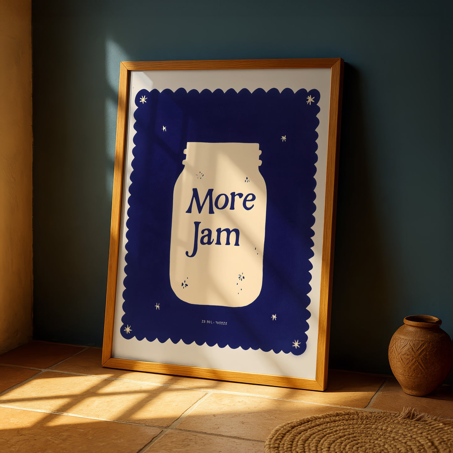 a framed poster with a blue background and a white jar illustration, placed on a wooden floor near a vase.