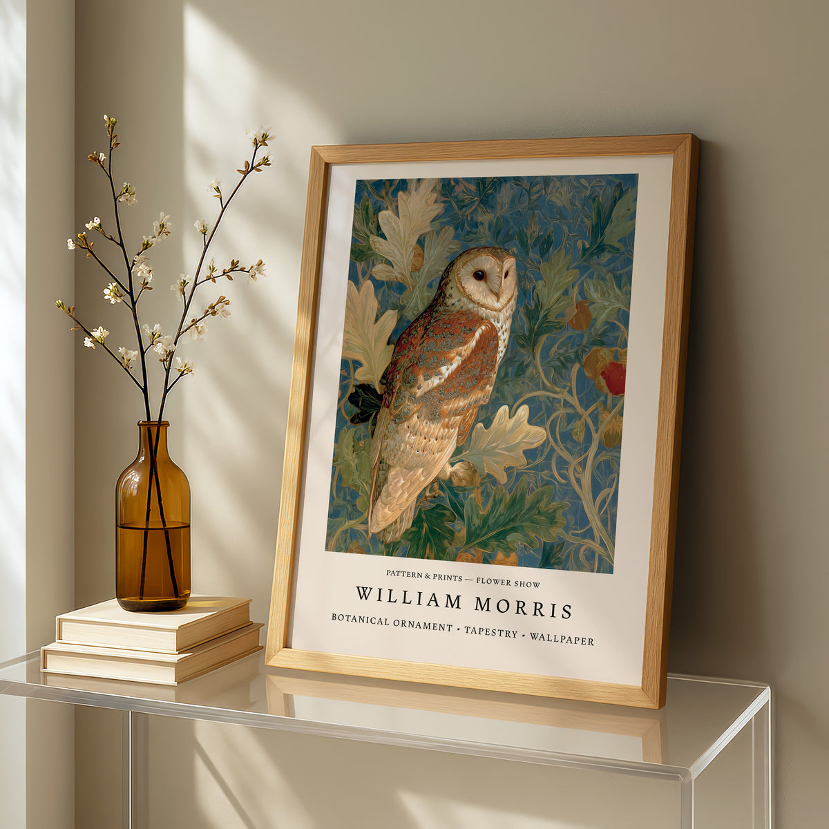 a framed painting of a brown owl perched on a branch, with a vase of white flowers and a stack of books on a table in the foreground.