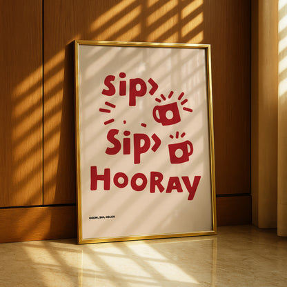 A framed poster with the text "Sip, sip, sip, hooray" in red letters, along with a red mug icon, is displayed on a wooden wall.