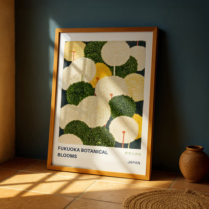 a framed poster of a floral design with the text "FUKUOKA BOTANICAL BLOOMS" and "JAPAN" printed on it. The poster is displayed on a wall, and there is a vase placed next to it.
