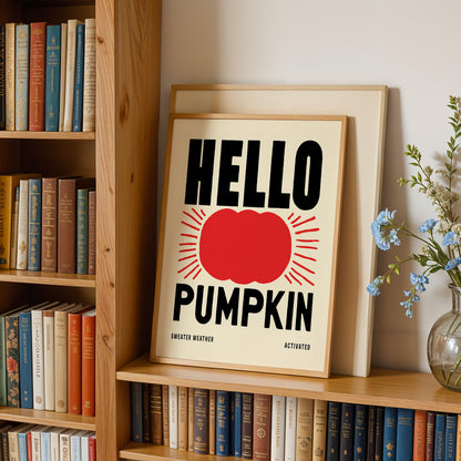 a framed poster with the text "HELLO PUMPKIN" displayed prominently on a bookshelf.