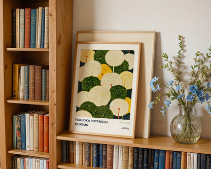 a wooden bookshelf with a framed print of a floral design on the top shelf, a vase of blue flowers on the bottom shelf, and a collection of books on the shelves below.