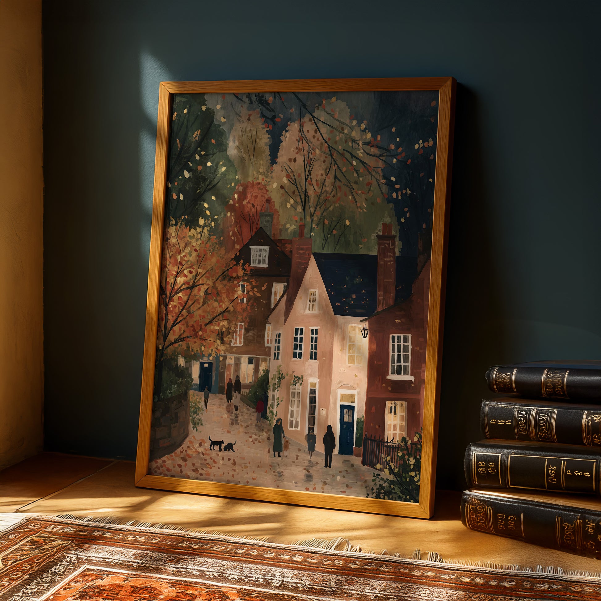 a framed painting of a quaint village scene, with a row of houses, trees, and people walking along a path.